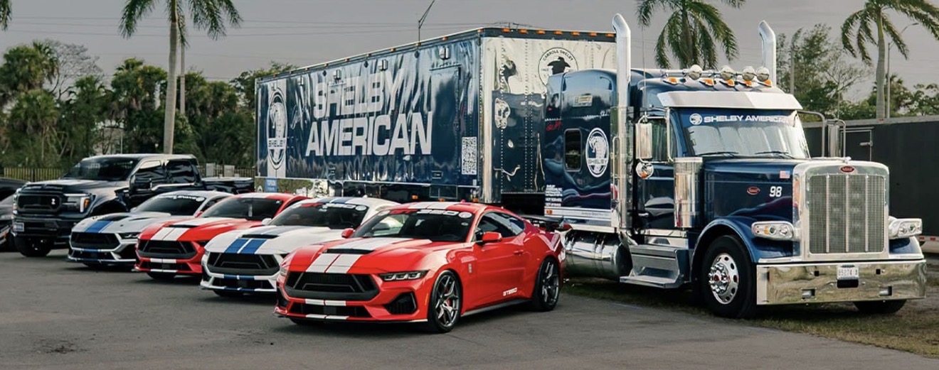 Shelby American transport rig with Shelby Mustangs lined up beside it